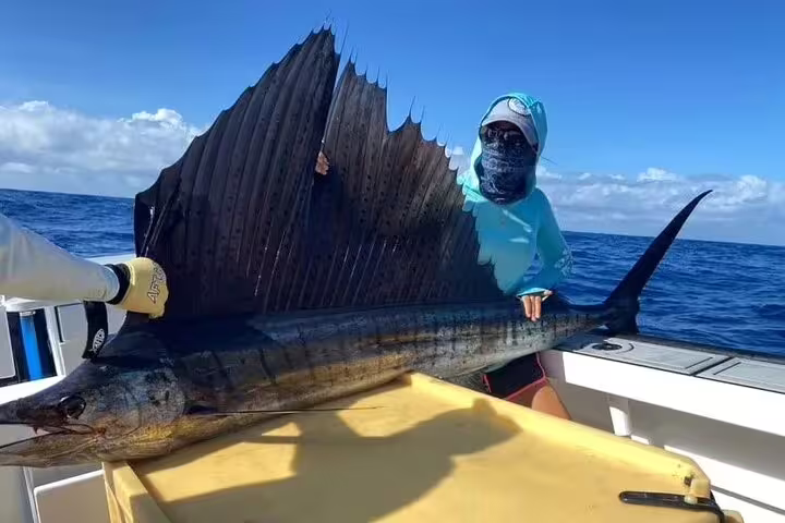 Fisher shows off a massive sailfish caught during an exhilarating Seychelles fishing tour.