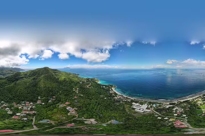 Panoramic aerial view of Seychelles coastline with vibrant greenery and azure ocean, ideal for a private island tour.