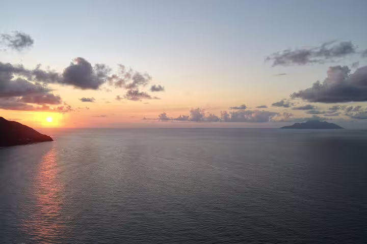 Breathtaking sunset over the Indian Ocean with silhouetted clouds, perfect for a Seychelles Island Tour experience.