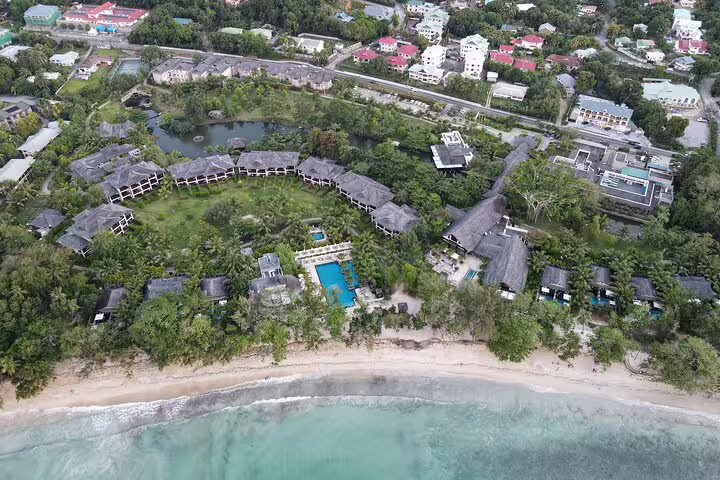 Aerial shot of luxury Seychelles resort by the beach, highlighting exclusive VIP transport and accommodation options.