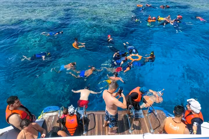 Boat stop at Shaab Samadai, Marsa Alam snorkeling tour with groups in crystal-clear Red Sea lagoon