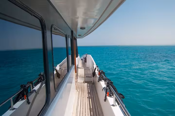 Boat deck cruising over clear Red Sea waters to Shaab Samadai reef for Marsa Alam snorkeling adventure