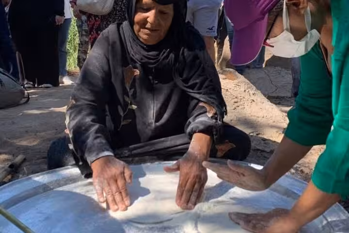 Local farm cooking demo at Shagie Farms eco-tour from Cairo, guests preparing fresh dough outdoors