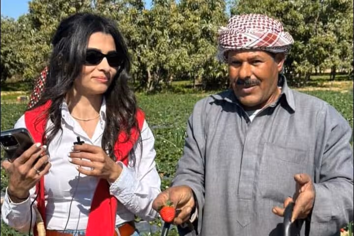 Farmer and guest holding fresh strawberries during Shagie Farms eco-tourism strawberry picking from Cairo
