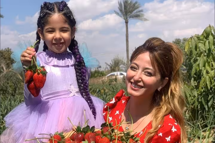 Mother and child show picked strawberries at Shagie Farms eco-tour from Cairo, family-friendly farm visit