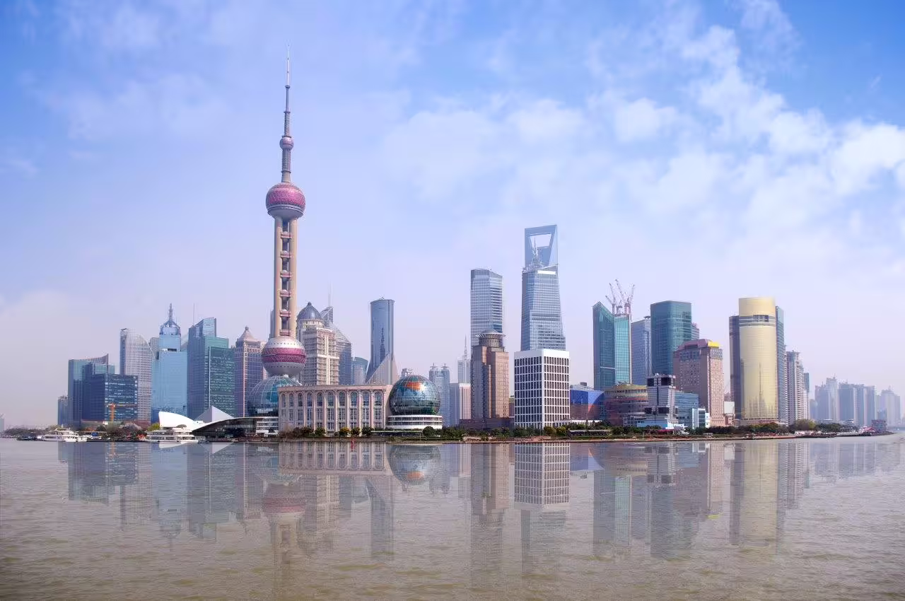 Shanghai skyline with iconic Oriental Pearl Tower reflecting in the Huangpu River, ideal for a private city tour.