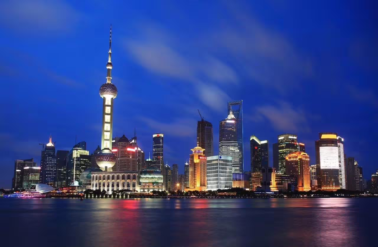 Shanghai skyline with Oriental Pearl Tower illuminated at night, showcasing vibrant cityscape on Chinese Ancient Heartland tour.