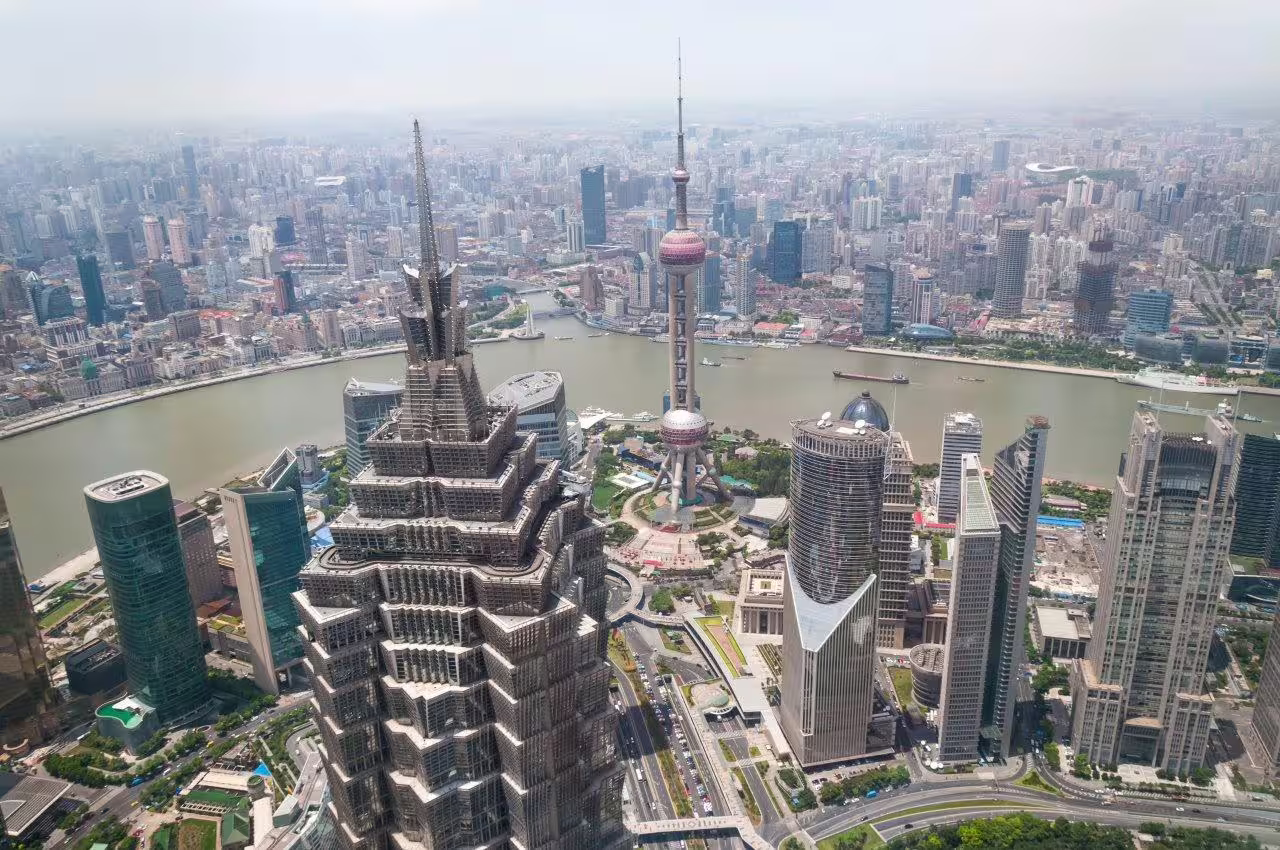 Aerial view of Shanghai's modern skyline featuring the iconic Oriental Pearl Tower and skyscrapers.