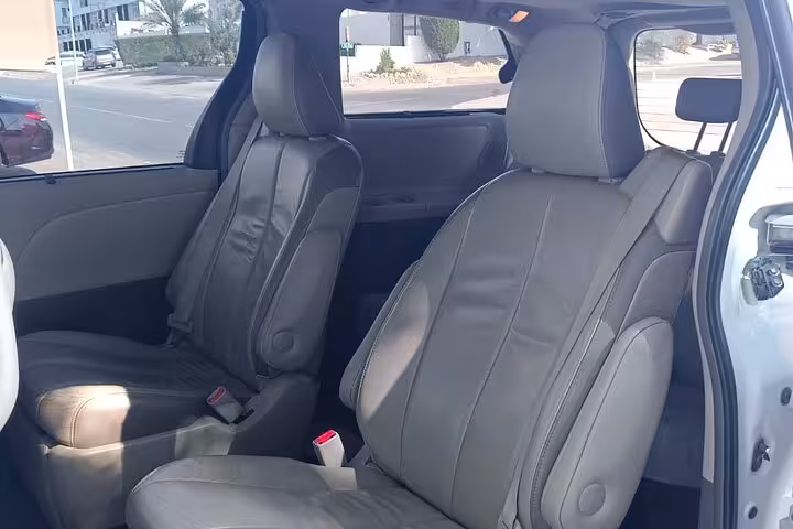 Comfortable leather interior of air-conditioned minivan for private departure transfer from Shangri-La resort to Muscat Airport