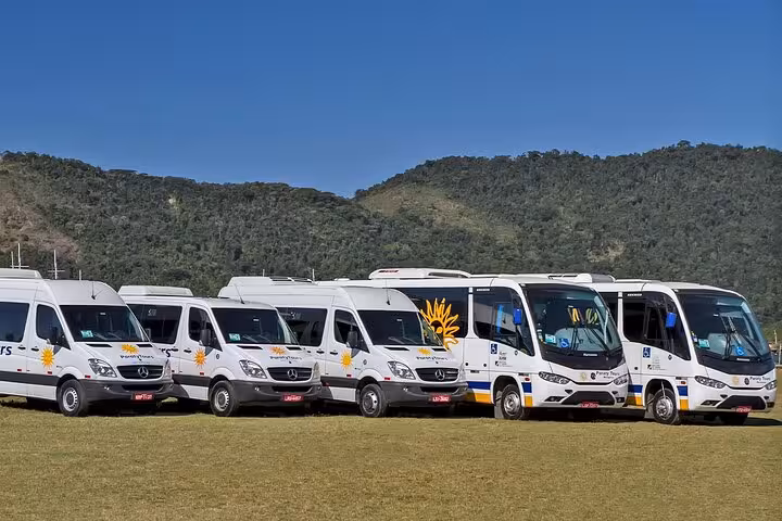 Fleet of white shuttle vans ready for shared transfer service from Ilha Grande to Paraty.