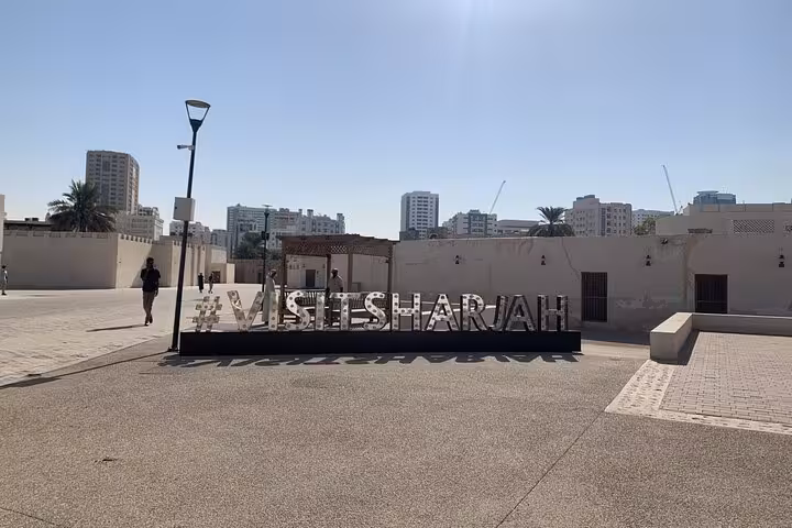 Visit Sharjah sign at heritage area, showcasing UAE culture, old town attractions and guided Emirates tour