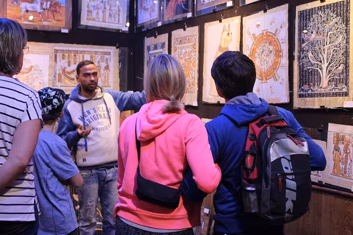 Cairo bazaar stop on Sharm to Cairo air tour, travelers viewing Egyptian papyrus art with local guide