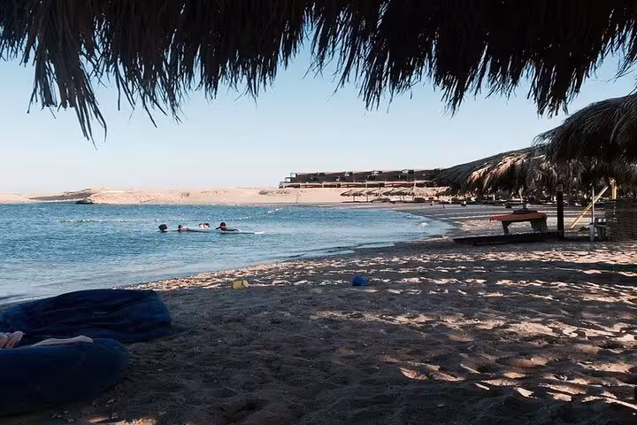 Shaded beach and calm lagoon at Sharm El Naga National Park on a semi-private day trip from Hurghada