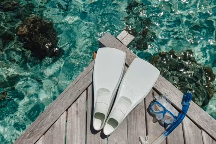 Snorkel fins and mask on jetty above crystal-clear Red Sea water on Sharm El Naga trip from Hurghada