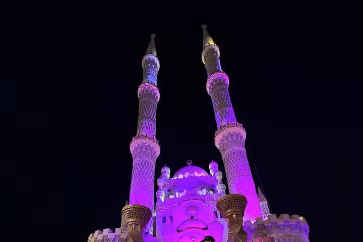Night view of Al Sahaba Mosque lit in purple, a top stop on the Sharm El-Sheikh city tour with seafood