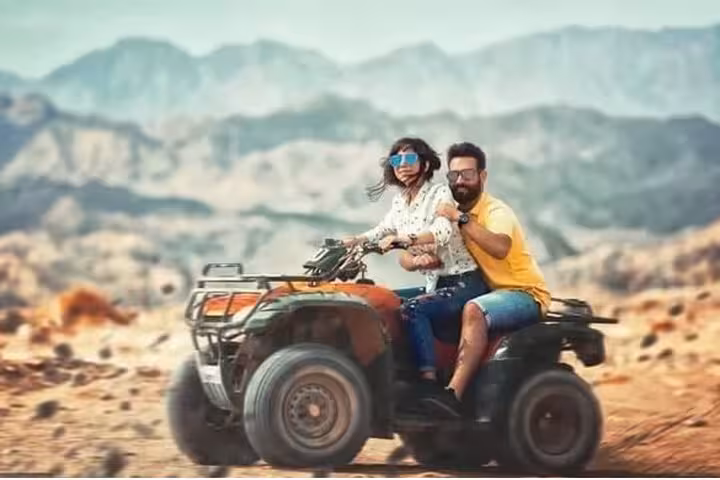 Couple riding an ATV quad through Sinai desert near Sharm El Sheikh on a sunrise or sunset adventure tour