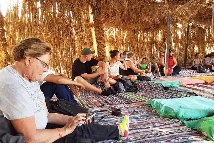 Tourists relax on Bedouin rugs in a desert tent on a Sharm El Sheikh safari and stargazing tour