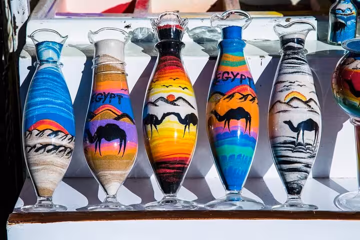 Egyptian sand art bottles with camel desert scenes at Sharm El-Sheikh bazaar, popular city tour souvenir