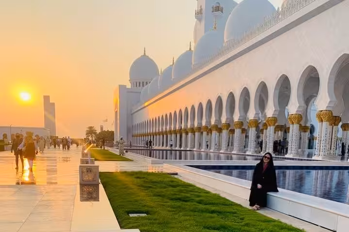 Sheikh Zayed Grand Mosque colonnade at sunset on Abu Dhabi city tour with Ferrari World ticket, reflecting pools