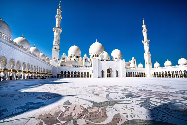 Marvel at the stunning white domes and minarets of Sheikh Zayed Grand Mosque, a highlight of the Abu Dhabi City Tour.
