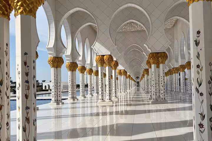 Reflecting pool and white domes at Sheikh Zayed Grand Mosque on a private Abu Dhabi city tour in your language