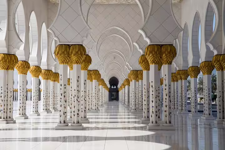 Sheikh Zayed Grand Mosque colonnade with floral marble pillars on a Dubai to Abu Dhabi private tour