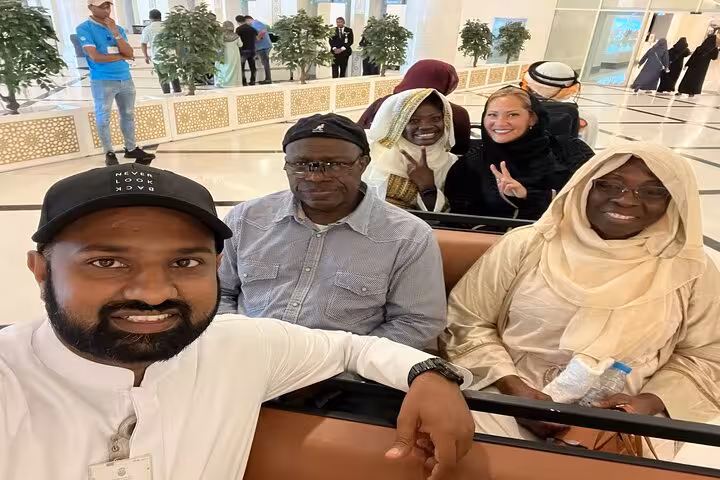Visitors relaxing inside Sheikh Zayed Grand Mosque Abu Dhabi on guided tour, with sunset option available