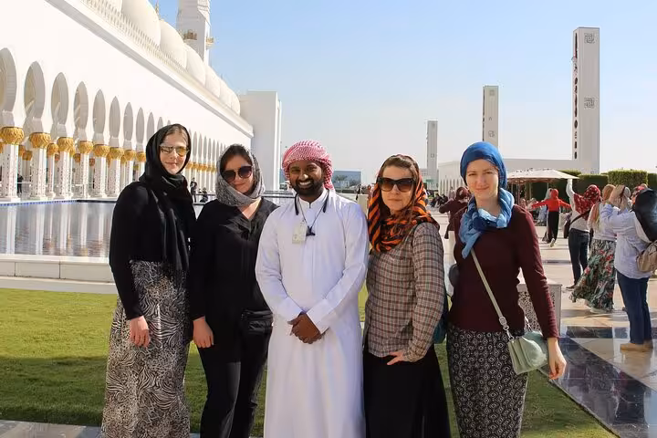 Group photo with guide at Sheikh Zayed Grand Mosque Abu Dhabi courtyard, guided visit with sunset option