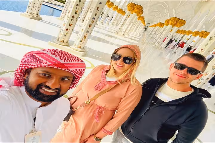 Guided Sheikh Zayed Grand Mosque tour with visitors in colonnade, Abu Dhabi sunset option available