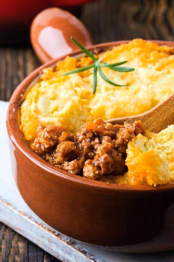 Delicious shepherd's pie with golden mashed potato topping in a rustic clay dish, ideal for culinary tours in Luxor.