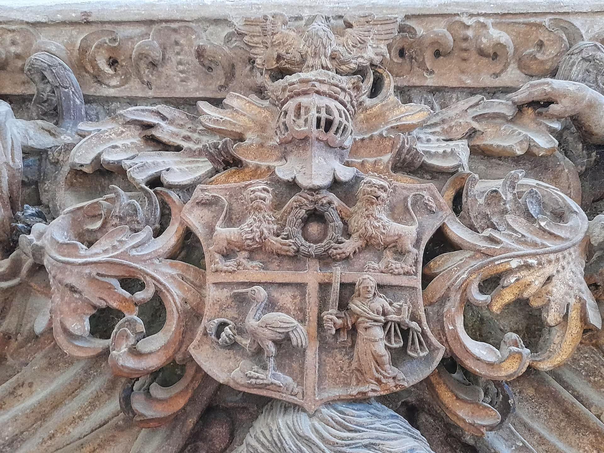 Detailed stone coat of arms carving on historic Sibiu cathedral wall visited during Corvin Castle day trip from Cluj