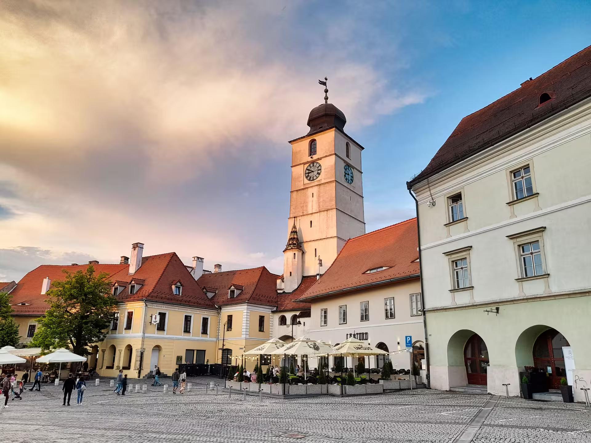 Sibiu Council Tower rising above the cobblestone Small Square on a Corvin Castle day trip from Cluj-Napoca