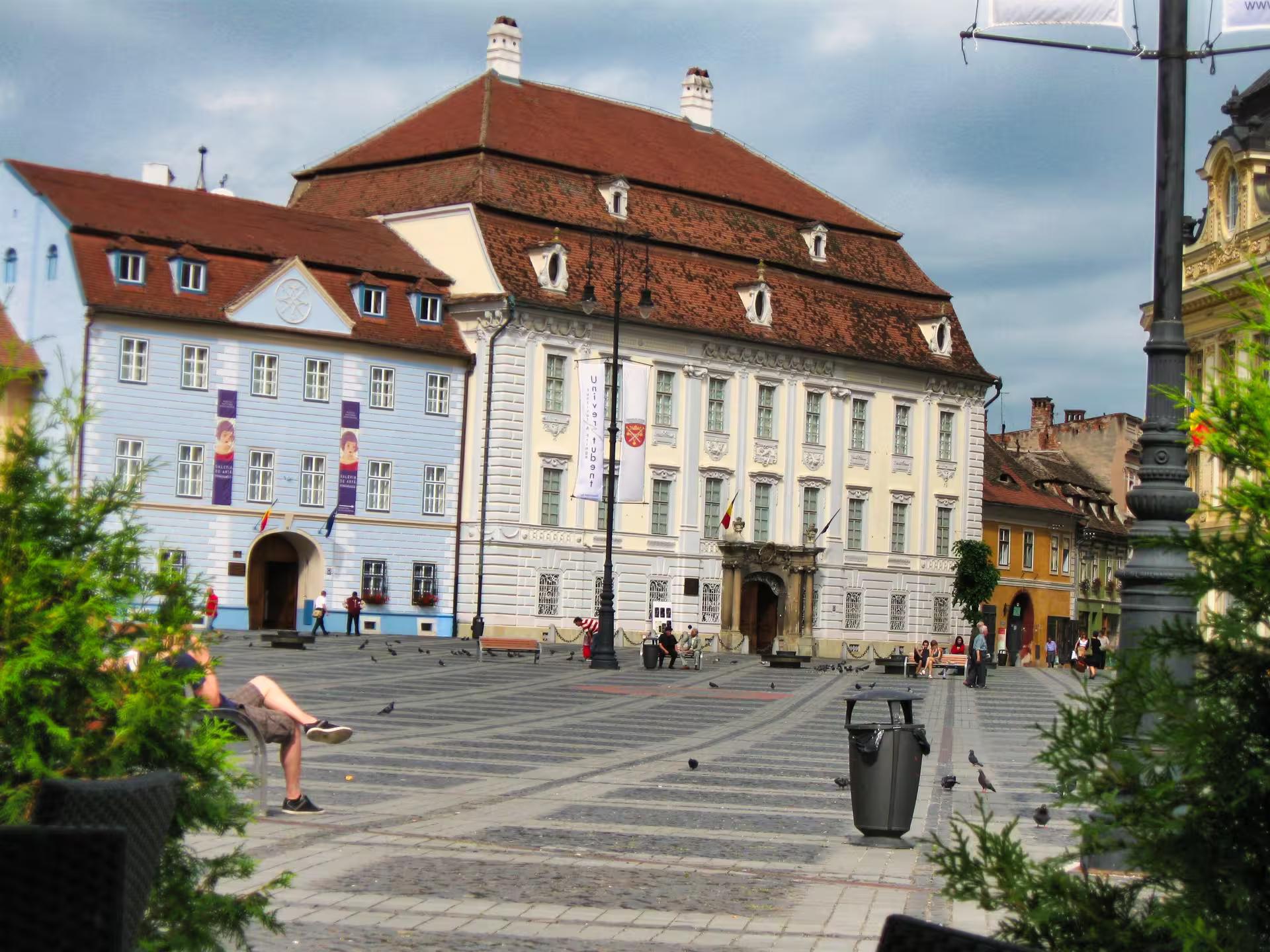 Historic Sibiu Grand Square showcasing baroque architecture and Brukenthal museum on a guided day trip from Cluj-Napoca