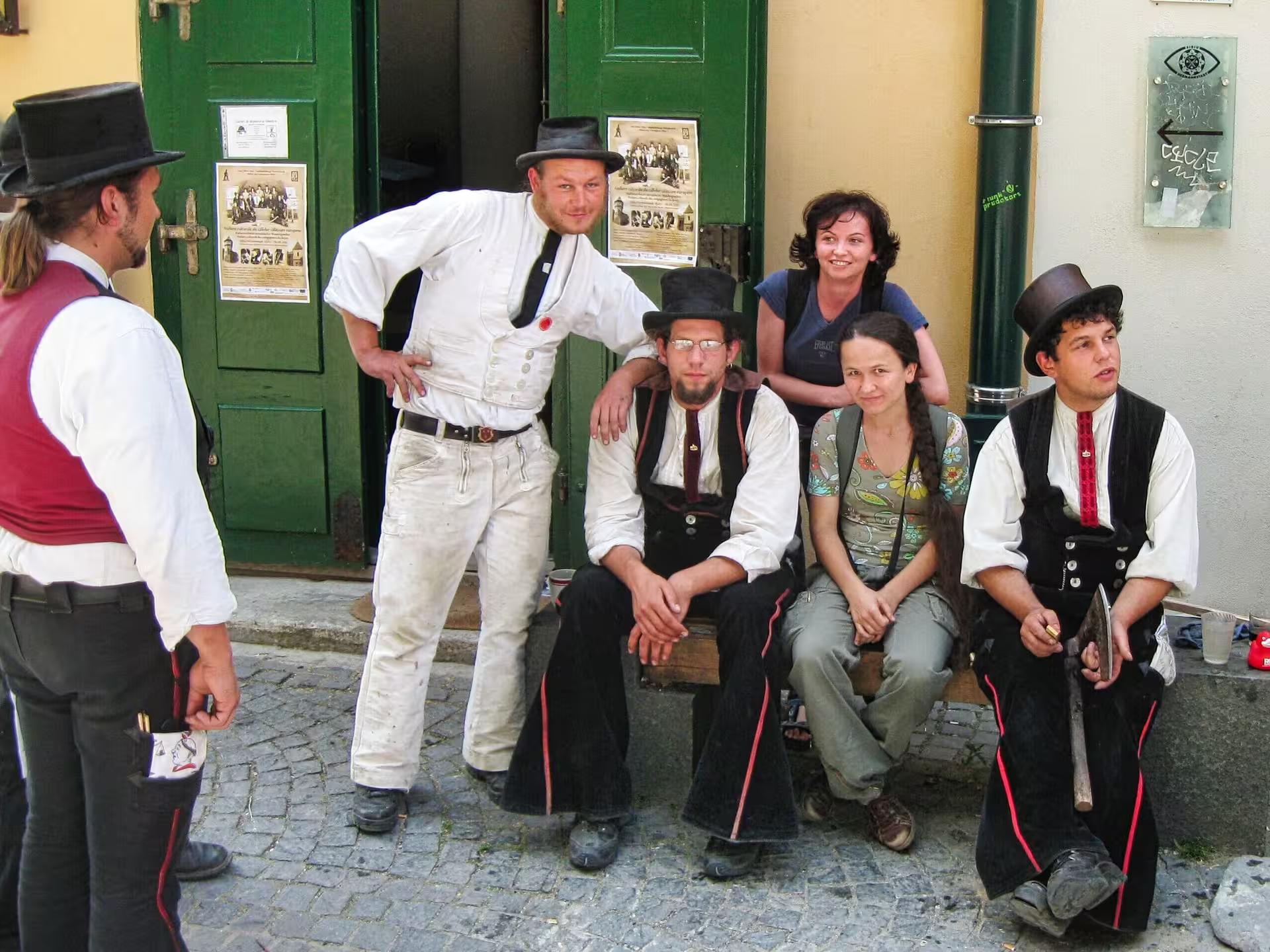 Traditional Romanian folk performers in historic costumes on cobblestone streets of Sibiu during a Cluj day trip