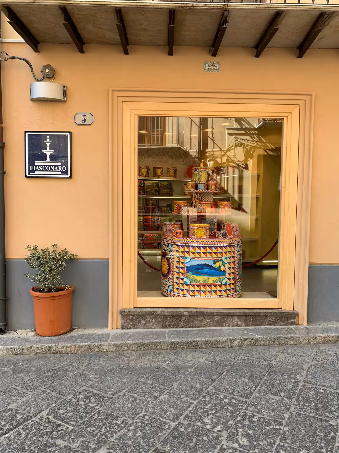 Colorful Sicilian cart and sweets displayed in a Fiasconaro pastry shop window in Castelbuono on a Palermo day trip