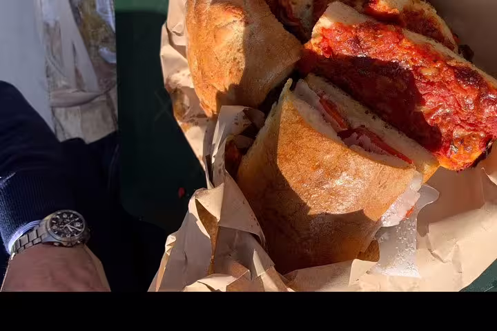Rustic Sicilian panini wrapped in paper during a scenic Scopello and Tonnara di Scopello private tour from Palermo