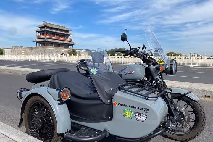 Sidecar parked in front of a historic gate in Beijing under a bright blue sky, ready for a private tour.