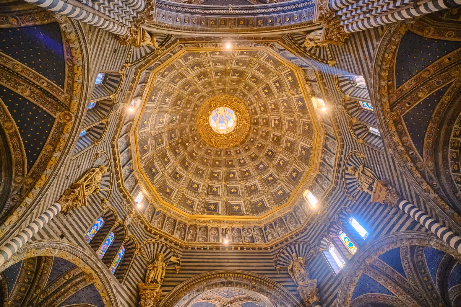 Intricate dome ceiling of Siena Cathedral, featuring golden accents on a Tuscany Highlights tour from Florence.