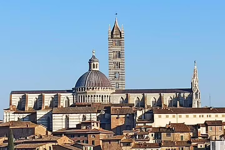 Panoramic view of Siena Cathedral and medieval rooftops on a clear day during a guided Discover Tuscany tour