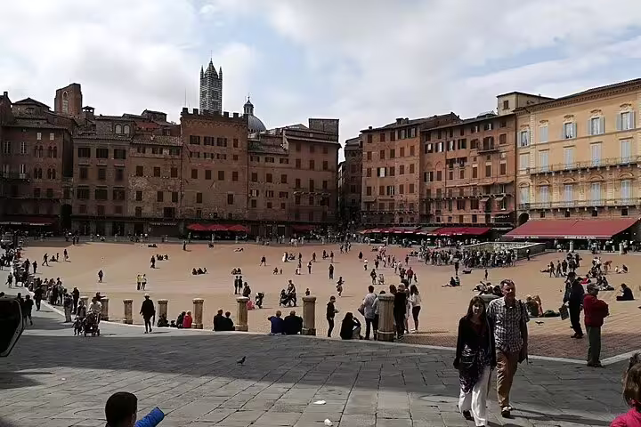 Visitors relaxing in Siena’s Piazza del Campo, a lively medieval square featured on Discover Tuscany Chianti day trips