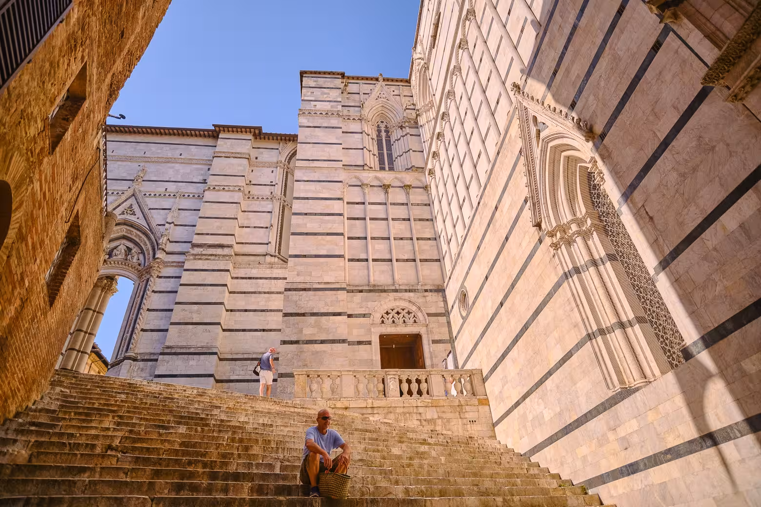 Visitors admiring the historic architecture of Siena's striped marble walls on a small-group Tuscany tour.