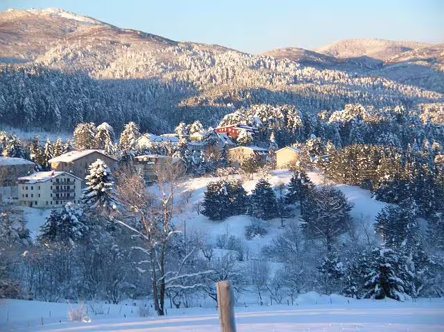 Snow-covered village and pine forests in Sila National Park, perfect for winter hiking, skiing and traditional mountain cuisine