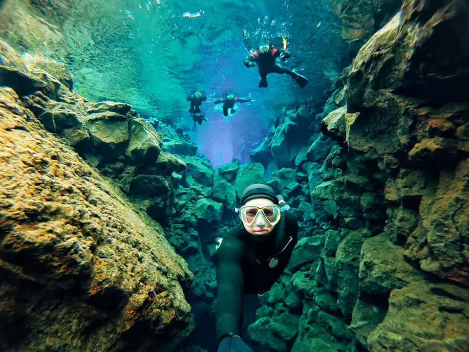 Snorkelers explore the crystal-clear waters of Silfra, Iceland, between tectonic plates, showcasing an unforgettable adventure.