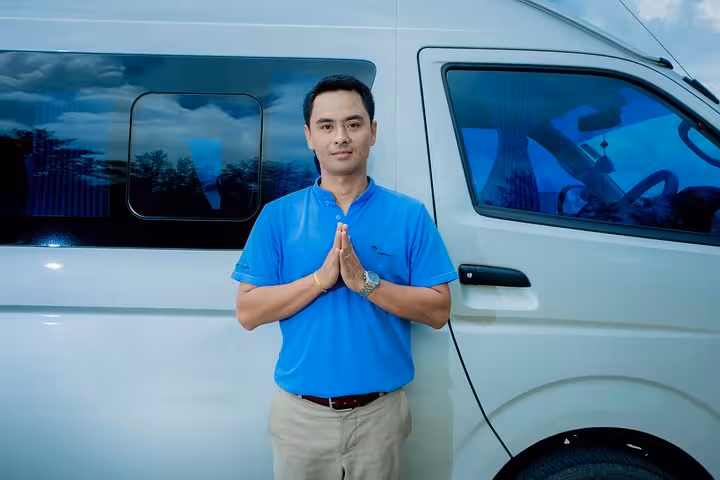 Professional driver greets guests beside private van for Singapore Changi Airport transfer service
