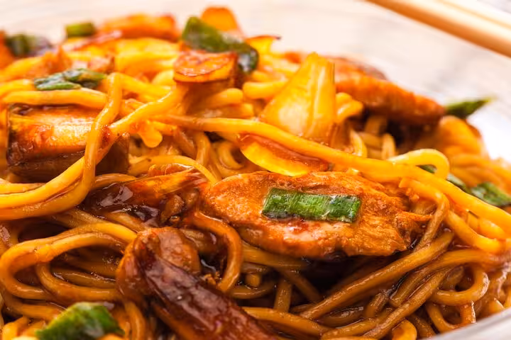 Savory stir-fried noodles with vegetables and succulent meat, showcased in the Singapore Chinatown Hawker Food Tour.