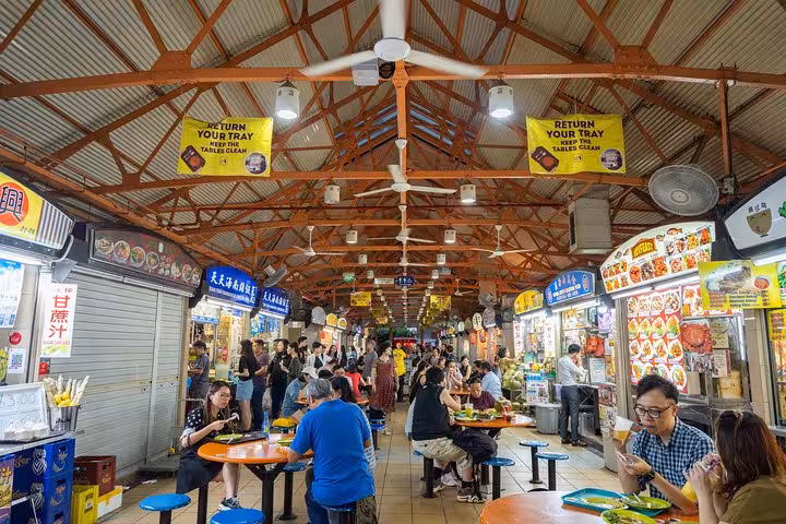Busy Singapore hawker center filled with locals and tourists enjoying authentic street food.