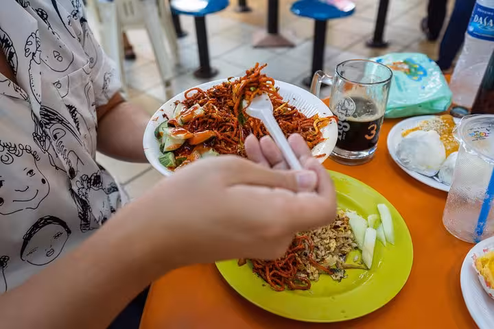 Close-up of vibrant noodles and traditional dishes at a Singapore hawker center, showcasing local street food delights.