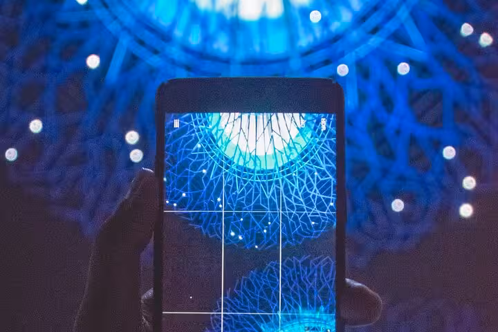 Capturing stunning blue light display with smartphone during Singapore Instagram walking tour.