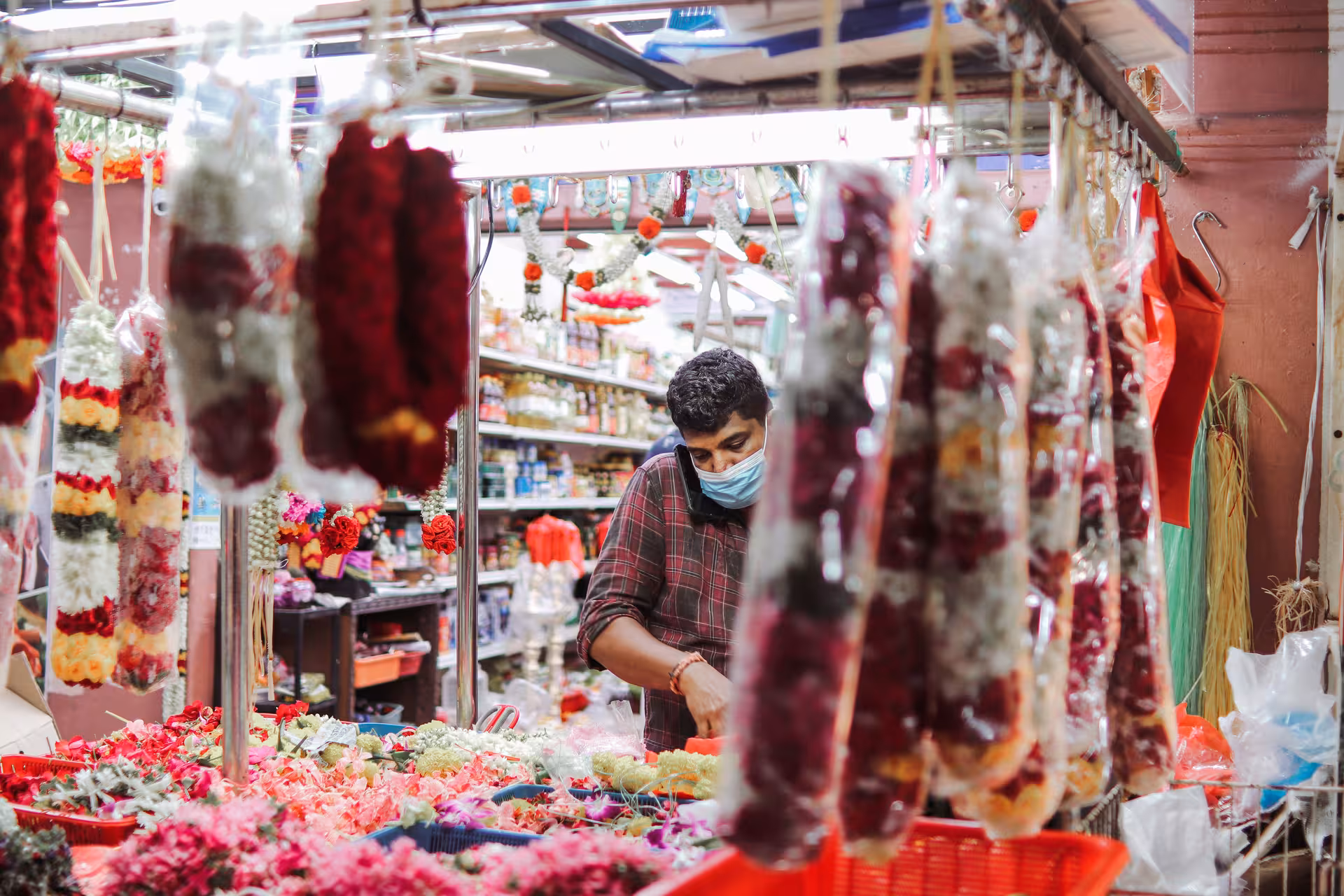 Florist arranging vibrant garlands in Singapore's Little India market during the Spice Discovery and Lunch Tour.