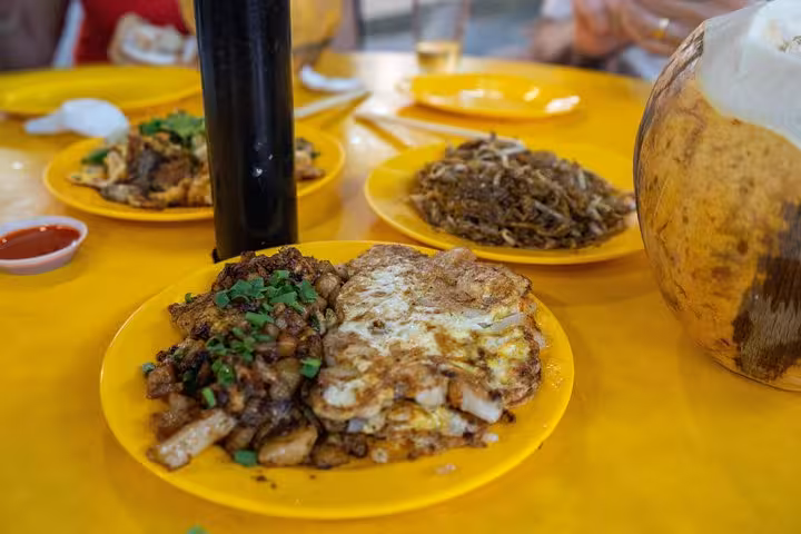 Close-up of traditional Singaporean street food including carrot cake and noodles, highlighting authentic culinary delights.